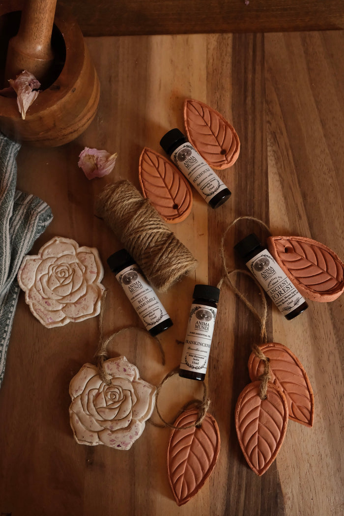 Small bottles with labels on a wooden surface with decorative elements like twine and flowers.