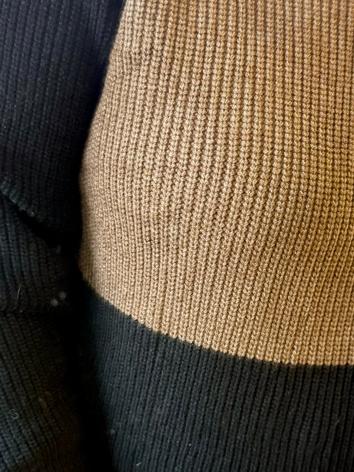Close-up rugby sweater knit with black and rust horizontal ribbed panels