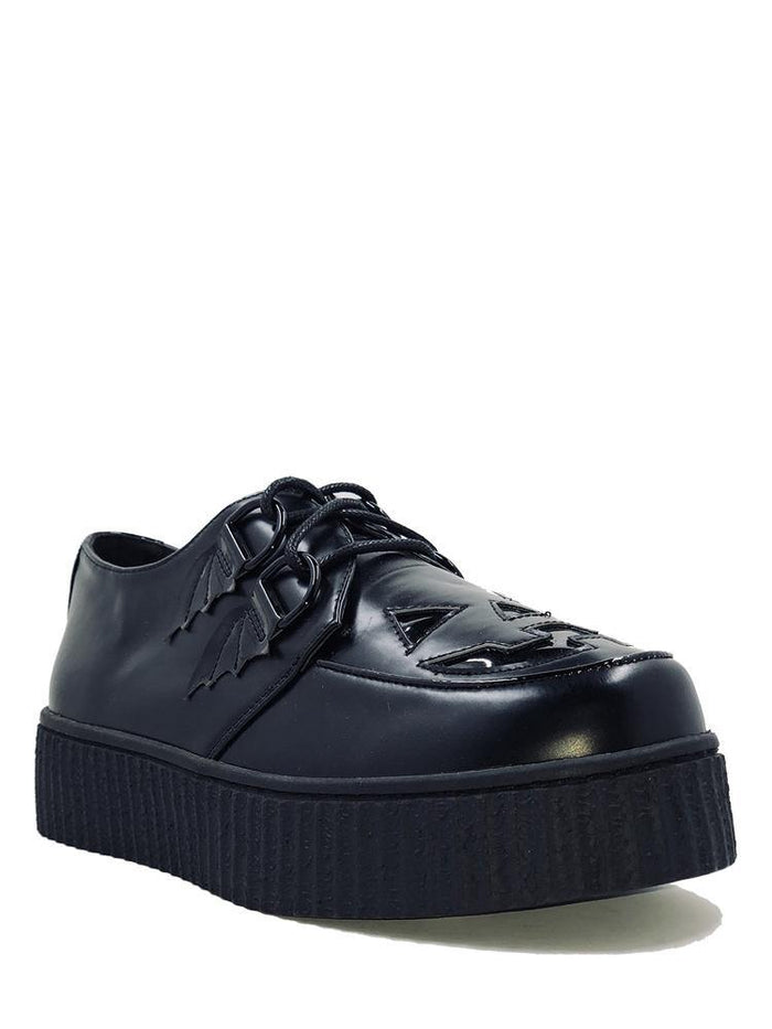 side of Black vegan leather creeper shoes with Jack-O-Lantern cut out face on top of shoe. Shoe has black round laces. Shoes are 100% vegan leather and black rubber outsole.