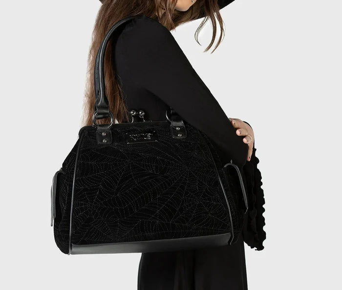 Model holding a black textured handbag against a white background