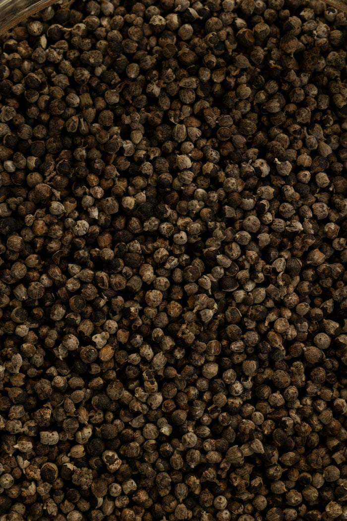 Close-up of dark brown peppercorns