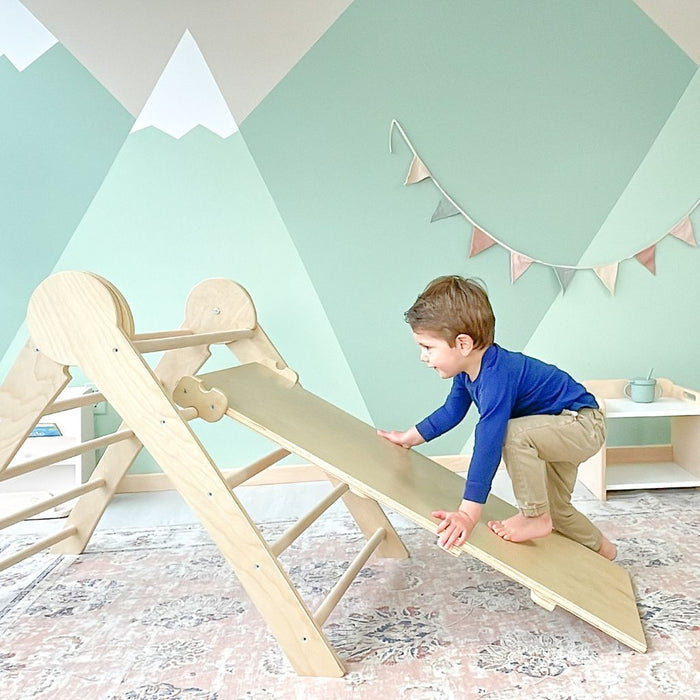 toddler climbing a wooden montessori triangle from Sapiens Child