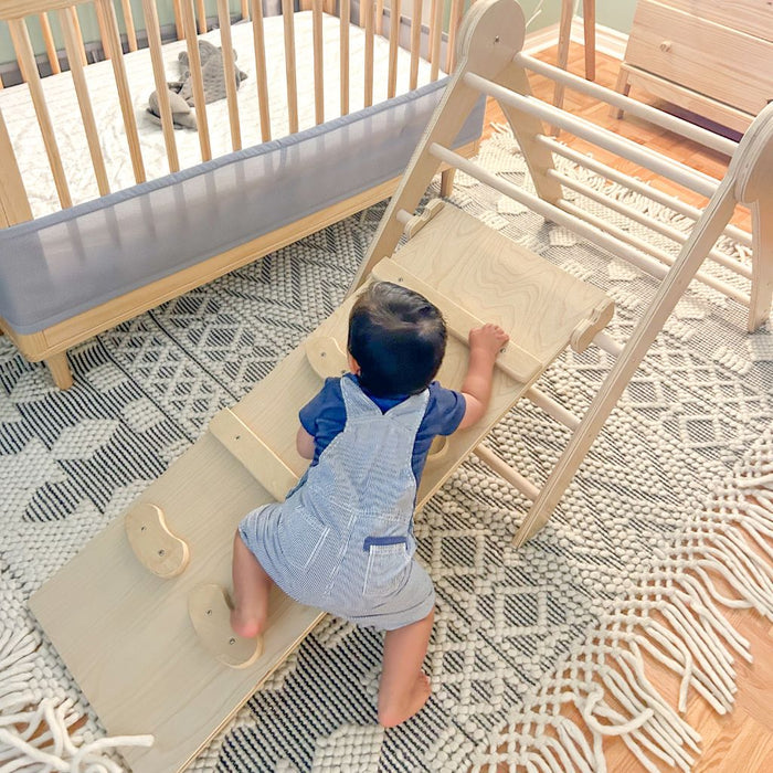 baby crawling and climbing using his baby feet and hands to climb helping with gross motor skills from Sapiens Child