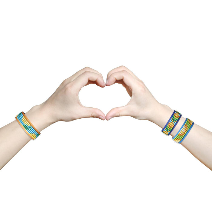 Two hands wearing colorful Diamond Dotz Gone Troppo Bracelets by Diamond Dotz form a heart against a white background—a fun DIY craft for kids and perfect for bracelet-making kit fans.
