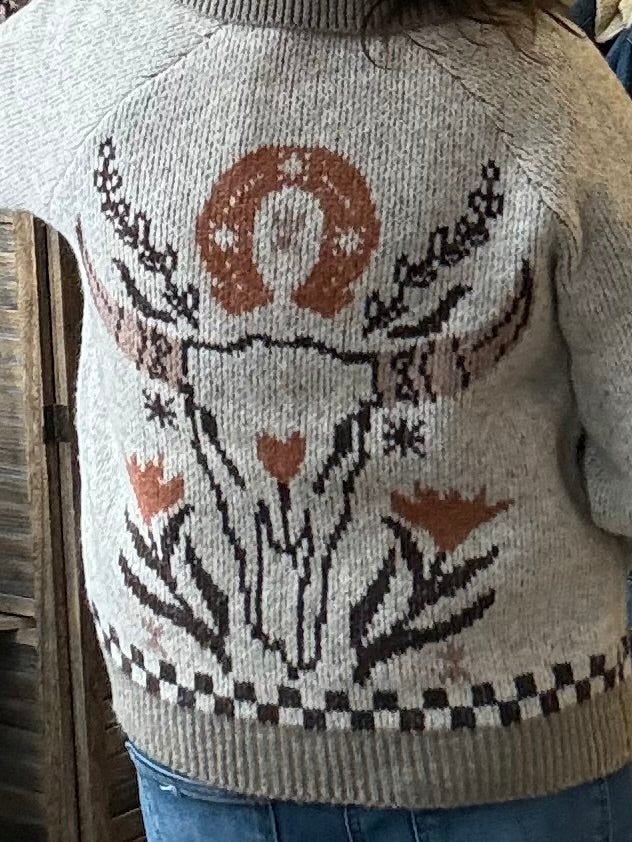 Back yoke of taupe knit cardigan with brown and black floral and vine motif