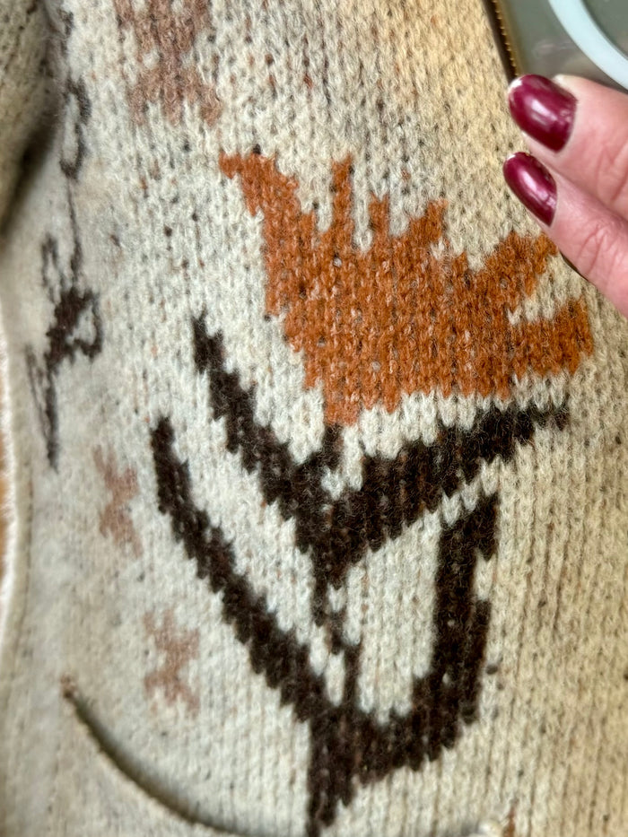 Close-up of taupe knit cardigan with orange and dark geometric motif