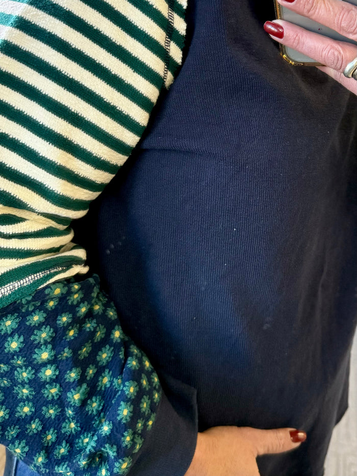 V-neck waffle knit t-shirt with dark blue body and green-and-cream striped sleeve cuff