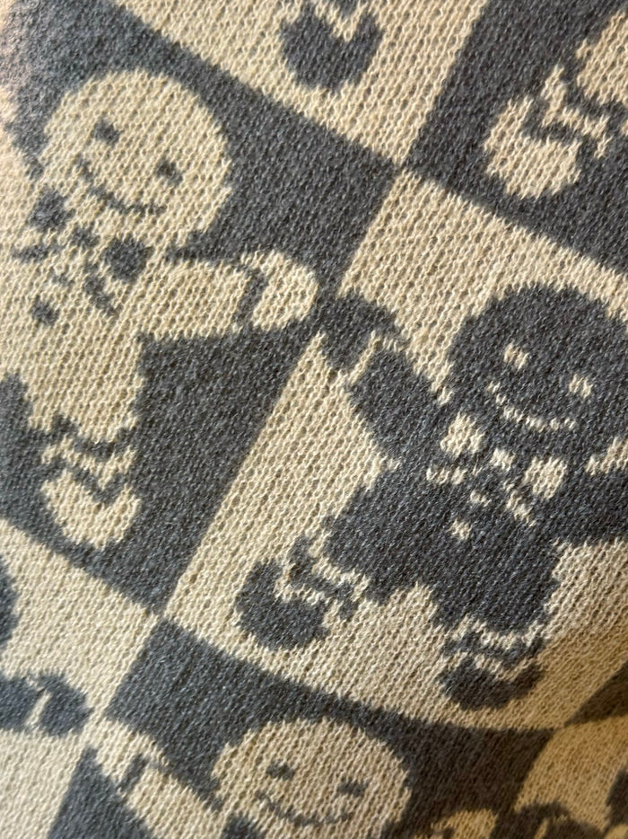 Close-up of knitted checkerboard gingerbread graphic in cream and dark gray