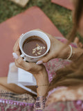Person holding a cup of coffee with a blurred background
