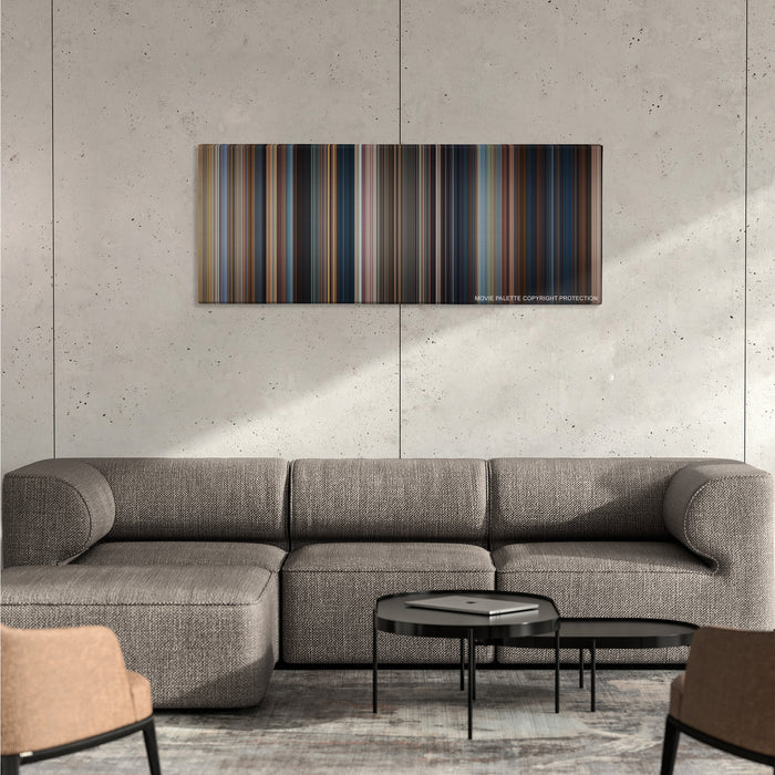 Jack Reacher color palette canvas on a concrete wall above a gray sectional sofa