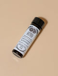 Roll-on bottle of Lavender Kashmir essential oil with a black cap on a beige background