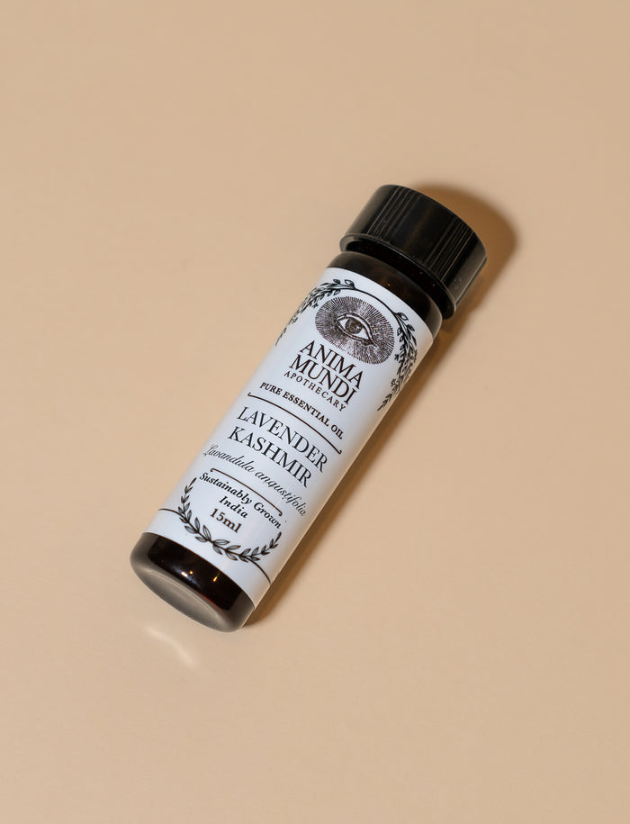 Roll-on bottle of Lavender Kashmir essential oil with a black cap on a beige background