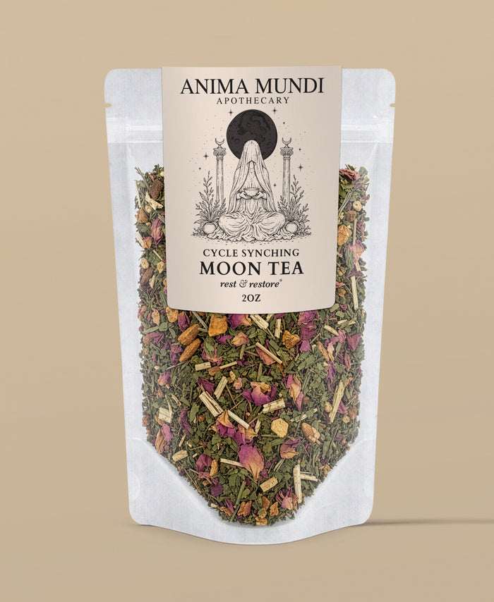 A stand-up pouch of Anima Mundi Apothecary Cycle Synching Moon Tea, featuring a cream label with a black moon goddess illustration and a clear lower section showing the dried herbal tea blend inside. The background is a solid warm beige.