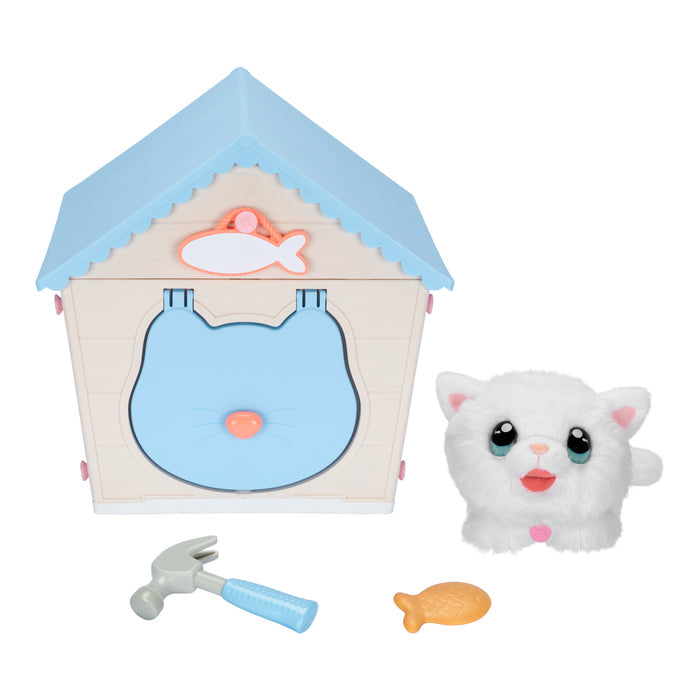 The Moose Toys Little Live Pets My Kitty's Home playset includes a blue-roofed cat house, a small white plush cat, a gray hammer with a blue handle, and a yellow fish-shaped toy or treat.