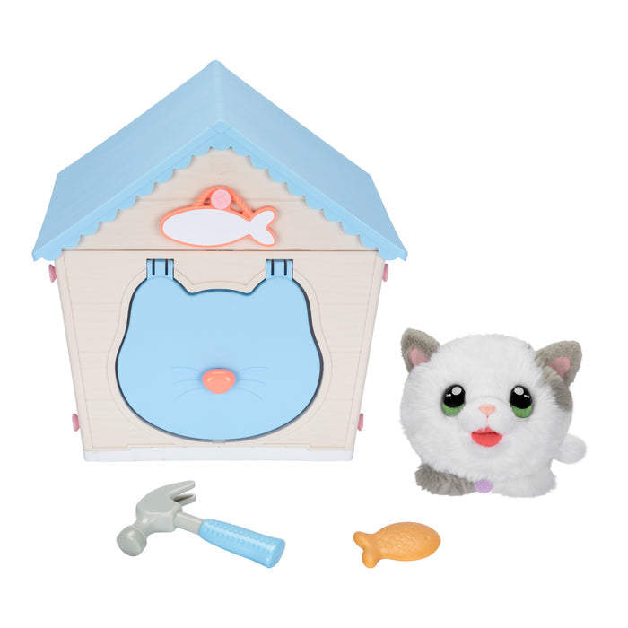 The Moose Toys Little Live Pets My Kitty's Home playset includes a white and gray plush cat with green eyes, a light blue and beige toy house, a fish-shaped treat, and a toy hammer for imaginative fun.