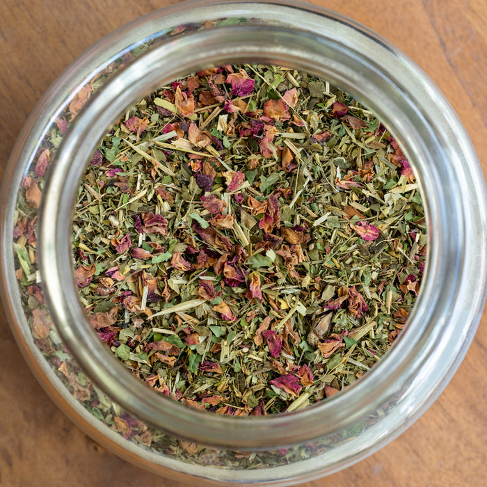 Jar of dried herbs on a wooden surface