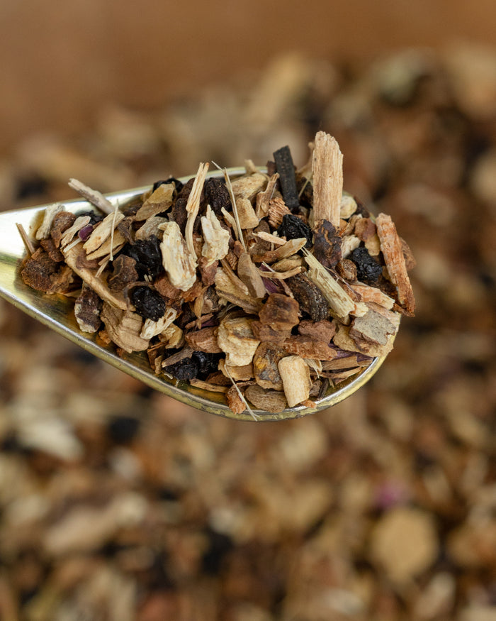 Spoonful of dried herbs and spices against a blurred natural background