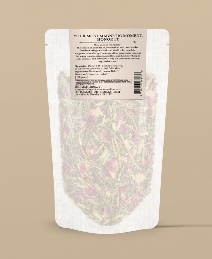 A stand-up pouch of herbal tea with a white label and clear lower section showing dried flowers and leaves inside, photographed on a solid beige background.