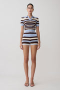 Woman wearing a striped outfit on a plain background.