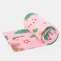 rolled pink gingerbread fleece throw, showing a soft, festive design with gingerbread man pattern
