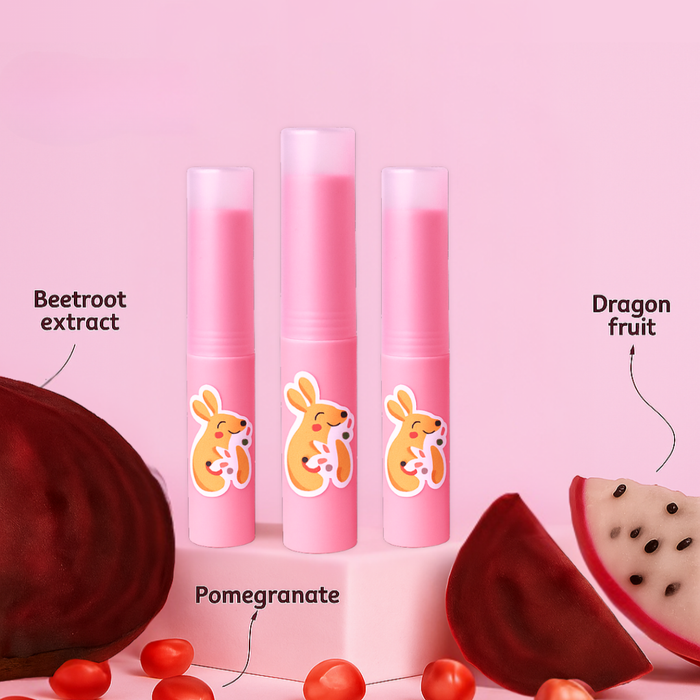 Three pink lip balms with cartoon rabbits on a pink background, featuring beetroot extract, pomegranate, and dragon fruit.