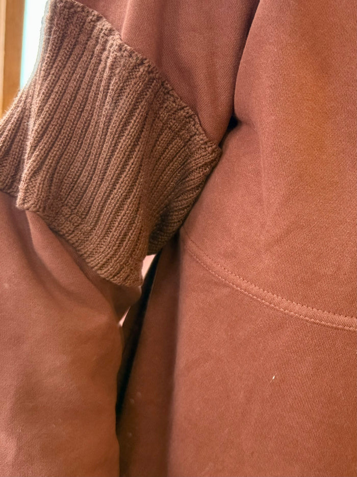 Rust quarter-zip pullover shirt close-up of ribbed cuff and kangaroo pocket