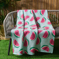 watermelon fleece throw draped over garden bench with bright pink tones