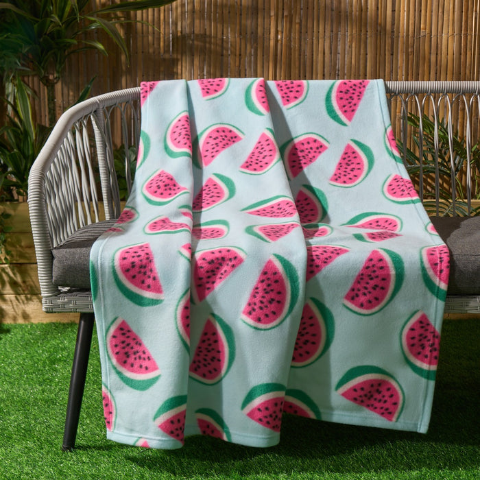 watermelon fleece throw draped over garden bench with bright pink tones